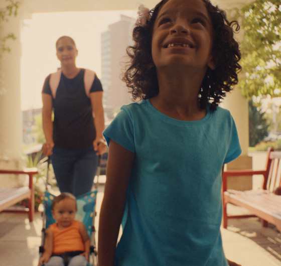 Young girl smiles as her and her family enter the RMHC Chapter House.